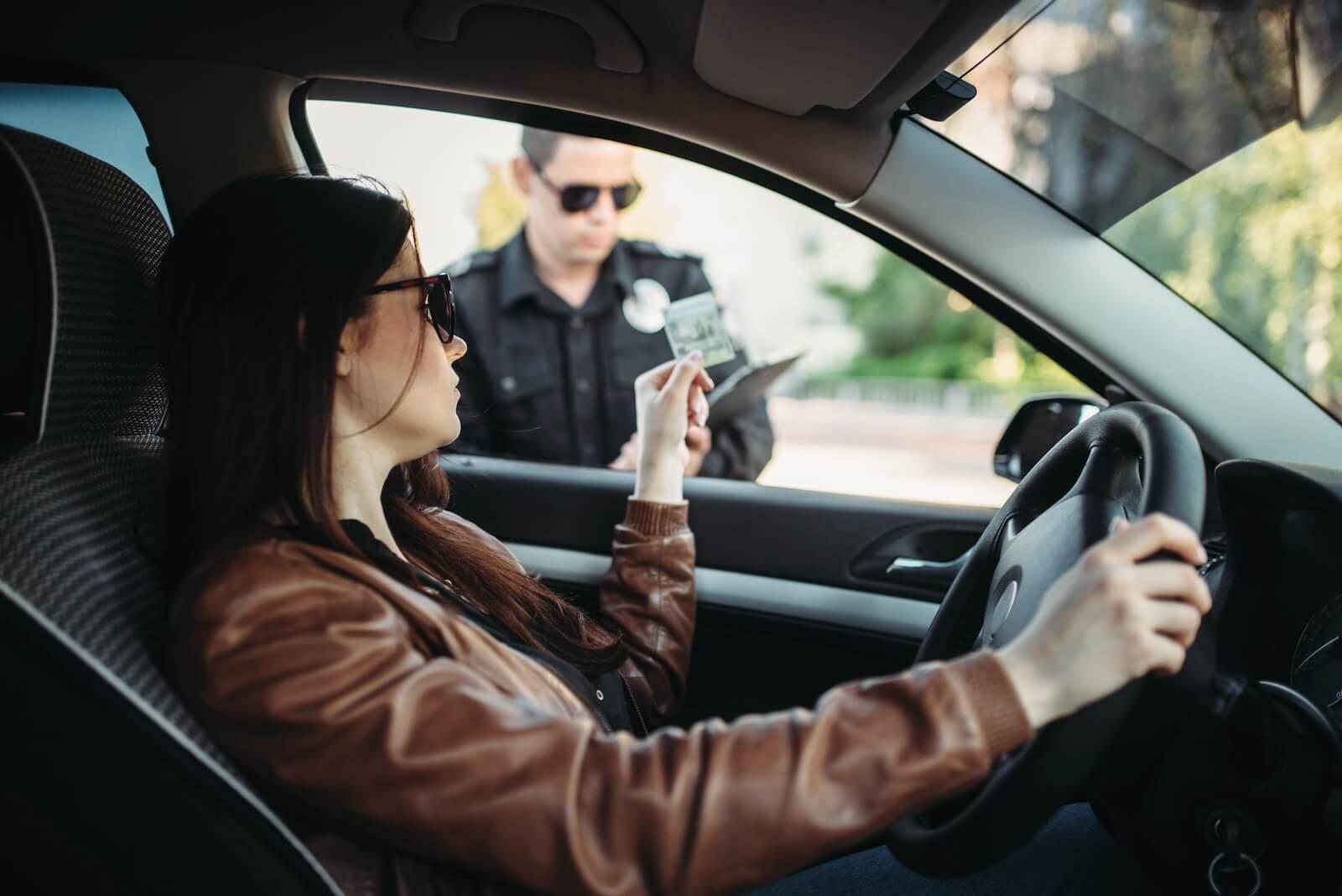 person handing license to police officer