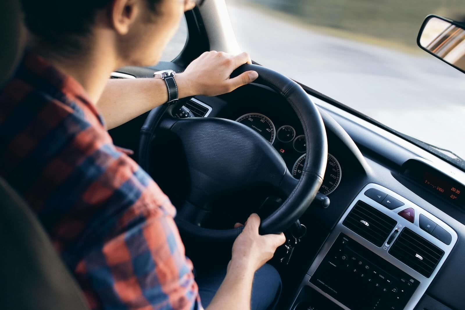 person with hands on steering wheel