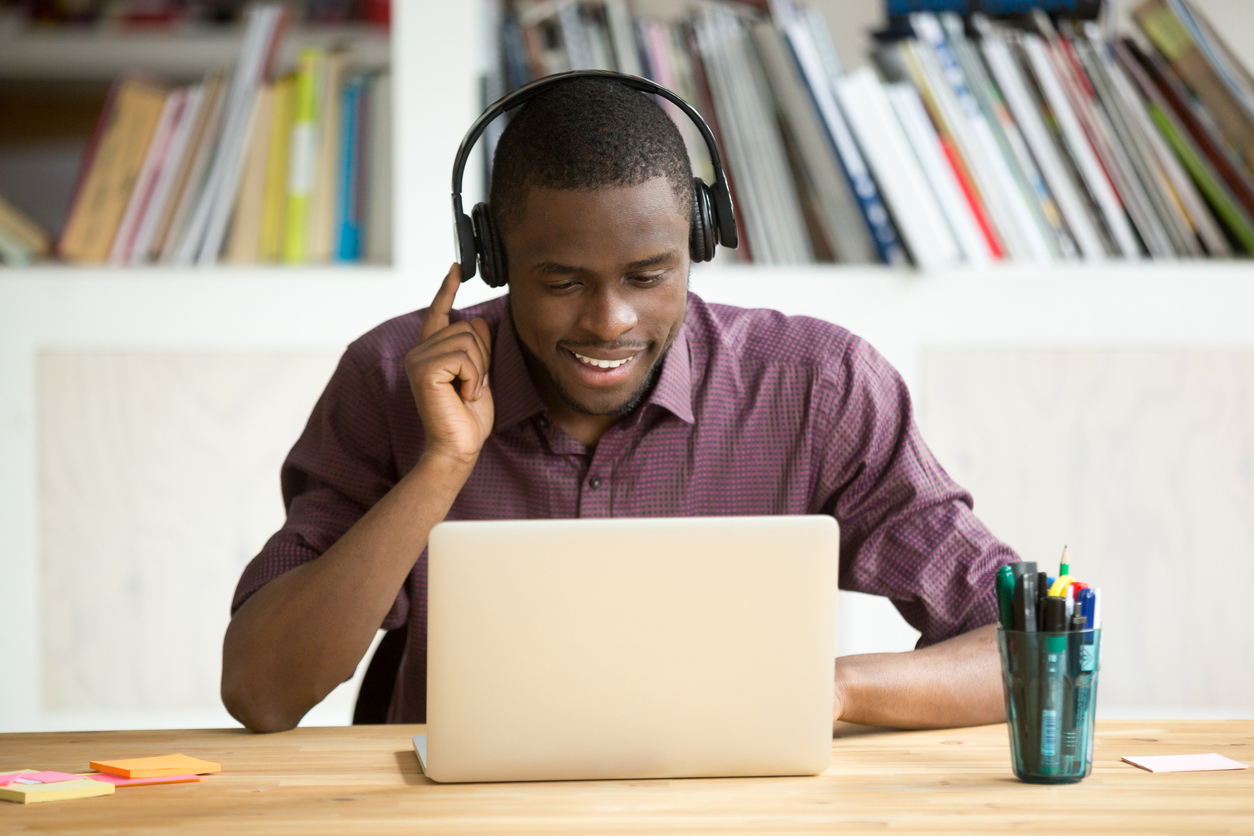 Man on laptop taking course and smiling